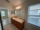 Well-lit bathroom featuring a double sink vanity with a large mirror and a window providing natural light at 1984 Estancia Circle # 29A, Kissimmee, FL 34741