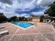 A sparkling community pool with clear blue water, surrounded by lounge chairs and a brick patio at 1984 Estancia Circle # 29A, Kissimmee, FL 34741