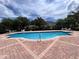A sparkling community pool with clear blue water, surrounded by lounge chairs and a brick patio at 1984 Estancia Circle # 29A, Kissimmee, FL 34741