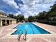 A sparkling community pool with clear blue water, surrounded by lounge chairs and a brick patio at 1984 Estancia Circle # 29A, Kissimmee, FL 34741