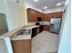 Well-lit kitchen featuring wood cabinets, black appliances, and stainless steel refrigerator at 1984 Estancia Circle # 29A, Kissimmee, FL 34741
