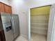 Walk-in pantry offering ample storage space with wire shelving and a stainless steel fridge at 1984 Estancia Circle # 29A, Kissimmee, FL 34741