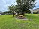 Community picnic area with wooden picnic tables set on concrete pads, surrounded by a green lawn and shady trees at 1984 Estancia Circle # 29A, Kissimmee, FL 34741