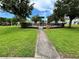 Community playground features a green canopy, slide, and surrounding safety fence amidst a lush green lawn at 1984 Estancia Circle # 29A, Kissimmee, FL 34741