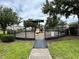 Community playground features a green canopy, slide, and surrounding safety fence amidst a lush green lawn at 1984 Estancia Circle # 29A, Kissimmee, FL 34741