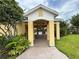 Community pool entrance with yellow pillars and a view of the pool area, surrounded by lush greenery at 1984 Estancia Circle # 29A, Kissimmee, FL 34741