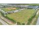 Aerial view of a baseball field and a large, open field in a residential community at 205 Cimarron Dr, Kissimmee, FL 34759