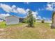 Landscaped backyard view features a shed and screened-in porch, enhanced by vibrant greenery at 205 Cimarron Dr, Kissimmee, FL 34759