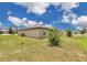 The back of the house is surrounded by a beautiful lawn and shrubbery on a sunny day at 205 Cimarron Dr, Kissimmee, FL 34759