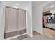 Clean bathroom features walk-in closet access, walk-in shower with curtain, and wood floors for easy maintenance at 205 Cimarron Dr, Kissimmee, FL 34759