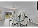 Bright dining room with a glass-top table, modern chandelier, and sliding glass doors at 205 Cimarron Dr, Kissimmee, FL 34759