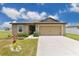 Charming single-story home showcasing a well-manicured lawn and welcoming two-car garage at 205 Cimarron Dr, Kissimmee, FL 34759
