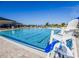 Community pool with lounge chairs, umbrellas, and a lifeguard stand under a blue sky at 205 Cimarron Dr, Kissimmee, FL 34759