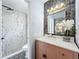 Stylish bathroom with modern fixtures, a vanity and mirror, plus a decorative vase of flowers at 2160 Churchill Downs Cir, Orlando, FL 32825