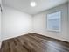 A bright, empty bedroom with hardwood-style flooring and a window at 2160 Churchill Downs Cir, Orlando, FL 32825