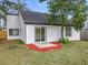 Back exterior of home shows sliding glass door leading to patio with landscaping at 2160 Churchill Downs Cir, Orlando, FL 32825