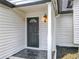 Exterior view showcasing the front door with black marble tiling, accented by a stylish hanging light at 2160 Churchill Downs Cir, Orlando, FL 32825