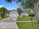 Charming one-story home boasts a well-maintained lawn, two-car garage, and beautiful landscaping at 2160 Churchill Downs Cir, Orlando, FL 32825