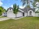 Beautiful white single-story home featuring an attached garage, manicured lawn and clean landscaping at 2160 Churchill Downs Cir, Orlando, FL 32825