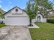 A charming one-story home featuring a two-car garage, fresh exterior paint, and a manicured lawn at 2160 Churchill Downs Cir, Orlando, FL 32825
