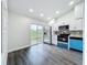 Bright kitchen with stainless steel appliances, custom backsplash and blue lower cabinets and slider door to the outside at 2160 Churchill Downs Cir, Orlando, FL 32825