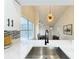 Modern kitchen with white countertops, stainless steel sink, and a view into the dining area with modern lighting at 2160 Churchill Downs Cir, Orlando, FL 32825