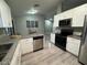 Well-lit kitchen with white cabinetry, granite countertops, and stainless steel appliances at 258 Magellan Dr, Kissimmee, FL 34758