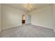 Carpeted bedroom featuring a modern chandelier and an ensuite bathroom at 2601 Blowing Breeze Ave, Kissimmee, FL 34744