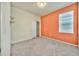 Bright bedroom features neutral carpet, a double window, walk-in closet, and an orange accent wall at 2601 Blowing Breeze Ave, Kissimmee, FL 34744
