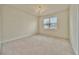 Spacious carpeted bedroom features a chandelier and a double window at 2601 Blowing Breeze Ave, Kissimmee, FL 34744