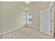 Bright bedroom featuring two windows, neutral carpet, and a convenient doorway at 2601 Blowing Breeze Ave, Kissimmee, FL 34744