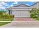 Charming single-story home with a brick driveway and attached two-car garage at 2601 Blowing Breeze Ave, Kissimmee, FL 34744