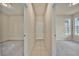 Hallway featuring tile floors and leading to two carpeted bedrooms at 2601 Blowing Breeze Ave, Kissimmee, FL 34744
