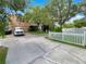 Spacious driveway and well-maintained exterior with a white picket fence at 2679 Rainbow Springs Ln, Orlando, FL 32828