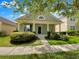 Charming home featuring a manicured lawn and inviting front porch with decorative columns at 2679 Rainbow Springs Ln, Orlando, FL 32828