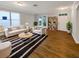 Bright living room with hardwood floors and white furnishings next to large window at 2679 Rainbow Springs Ln, Orlando, FL 32828