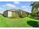 Expansive backyard with manicured lawn and mature plantings around the house at 2895 Apache Ct, The Villages, FL 32163