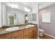Bathroom featuring a double vanity with two sinks, wooden cabinets, and a large mirror at 2895 Apache Ct, The Villages, FL 32163