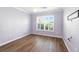 Bedroom with wood look flooring, white trim and a window with white shutters at 2895 Apache Ct, The Villages, FL 32163