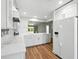Kitchen featuring white cabinets, hardwood floors, stainless steel appliances, and an island at 2895 Apache Ct, The Villages, FL 32163