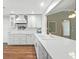 Kitchen with white cabinets and countertops, an island, and hardwood flooring at 2895 Apache Ct, The Villages, FL 32163