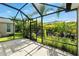 Screened patio with lovely view of backyard landscaping and tropical plants at 2895 Apache Ct, The Villages, FL 32163