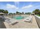 Large community pool area with plenty of seating, lounge chairs, and umbrellas at 2895 Apache Ct, The Villages, FL 32163