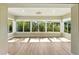 Light-filled sunroom featuring a wall of windows and wood-look floors at 2895 Apache Ct, The Villages, FL 32163