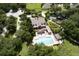 Community clubhouse featuring a sparkling pool, surrounded by verdant landscaping and mature trees in aerial view at 30210 Donnington Loop, Mount Dora, FL 32757