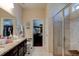 A modern bathroom with a double vanity, walk-in shower, and a walk-in closet at 30210 Donnington Loop, Mount Dora, FL 32757