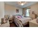 Charming bedroom featuring wicker furniture, hardwood floors, and a cozy floral comforter at 30210 Donnington Loop, Mount Dora, FL 32757
