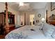 A traditionally designed bedroom with dark wooden furniture and multiple doors at 30210 Donnington Loop, Mount Dora, FL 32757