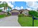 Beautiful single-story home with a well-manicured lawn, and a two-car garage on a sunny day at 30210 Donnington Loop, Mount Dora, FL 32757