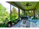 Inviting screened lanai featuring comfortable wicker furniture and a beautiful view of lush landscaping and trees at 30210 Donnington Loop, Mount Dora, FL 32757